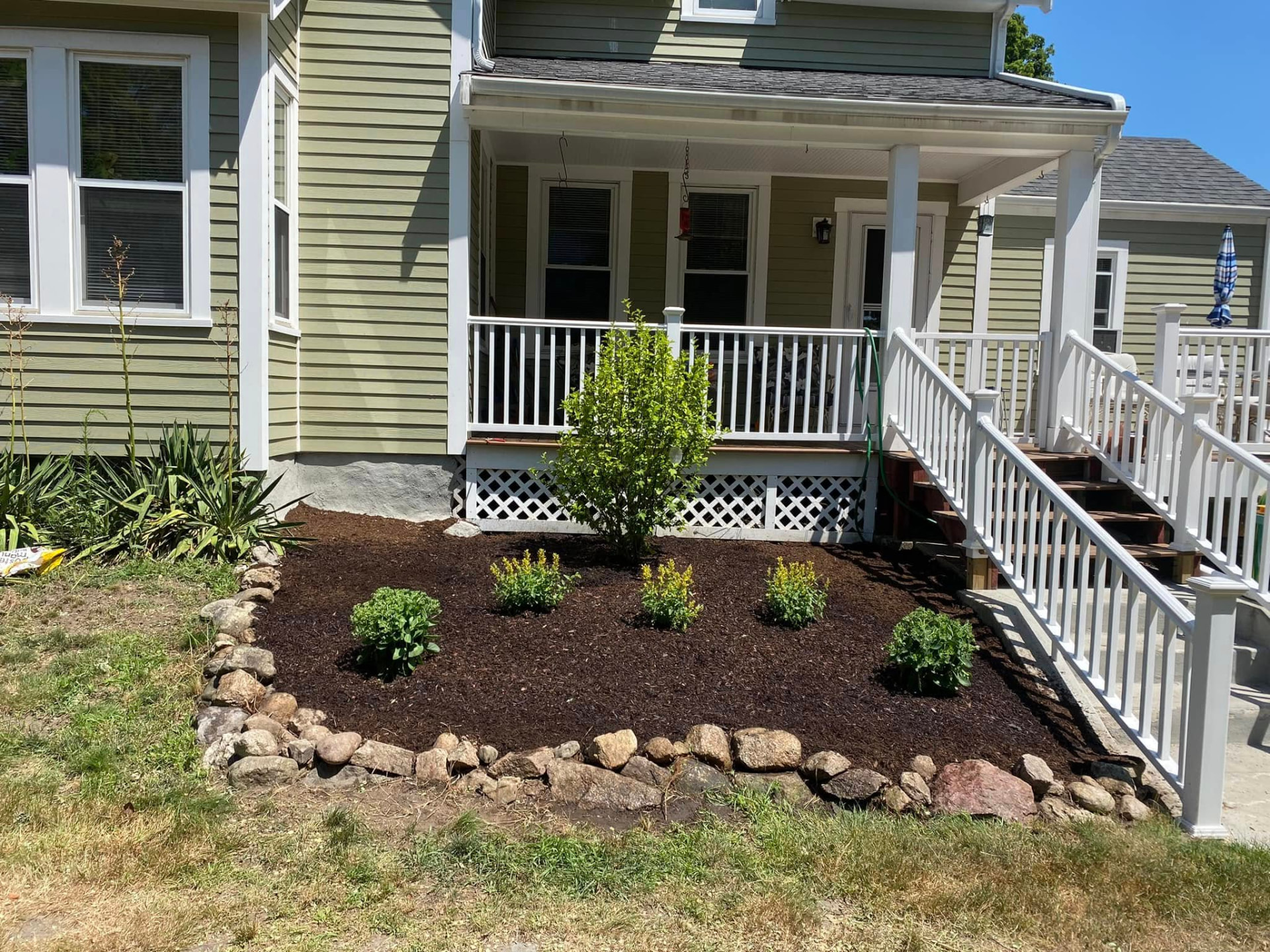 Freshly planted and mulched garden bed beside a front walkway
